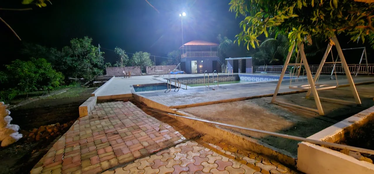 The farm after sunset, with illuminated paths and water feature